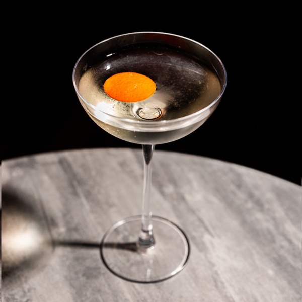 Black Seas cocktail, a variation of a Martinez using rakija, in a coupe glass, garnished with an orange twist