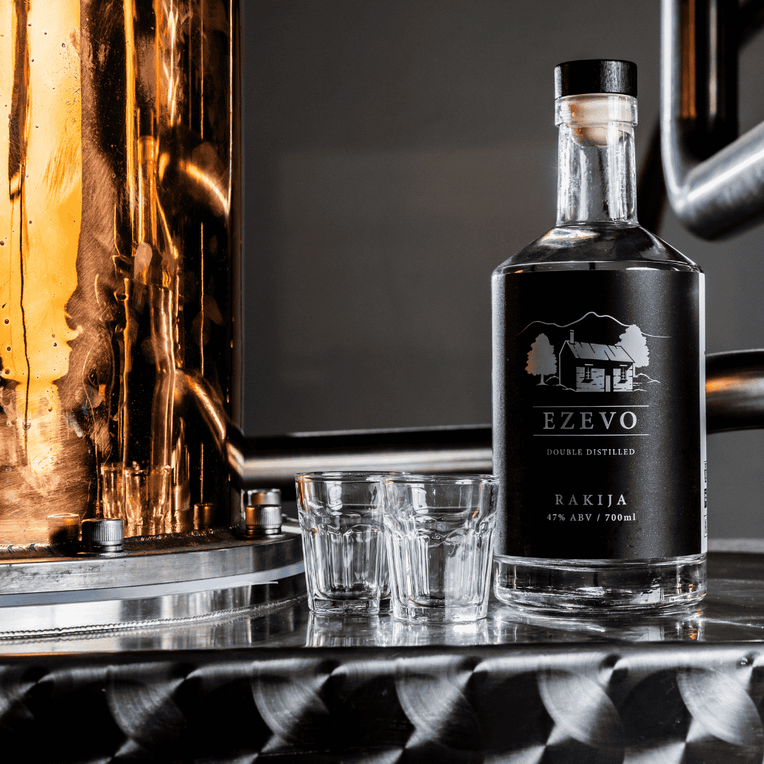 Ezevo rakija bottle with glasses on a reflective surface